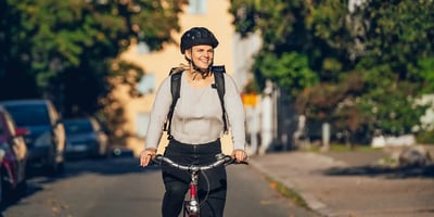 Nainen pyöräilee työmatkalla työsuhdepyörällä