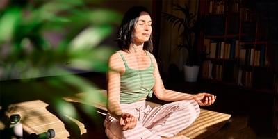 Nainen meditoi viherkasvin vieressä