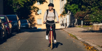 A woman is bicycling in a city