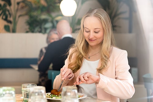 Nuori nainen syömässä ateriaa lounasravintolassa